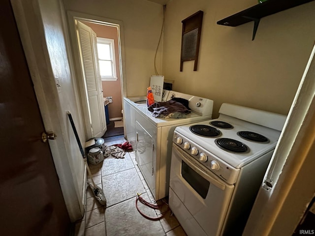 kitchen with white range with electric stovetop, light tile patterned floors, and washing machine and clothes dryer