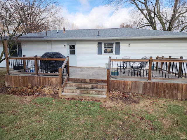 rear view of property featuring a deck and a yard