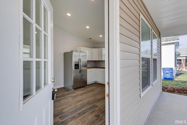 kitchen with white cabinets, dark hardwood / wood-style floors, and stainless steel refrigerator with ice dispenser