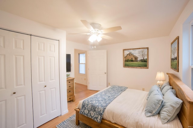 bedroom featuring a closet, light wood-style flooring, and a ceiling fan