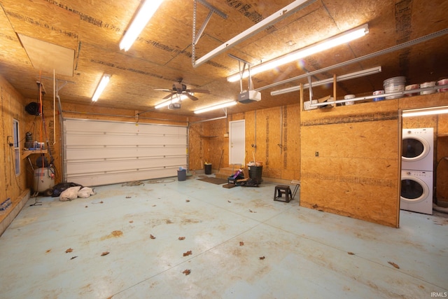 garage featuring stacked washer and dryer and a garage door opener