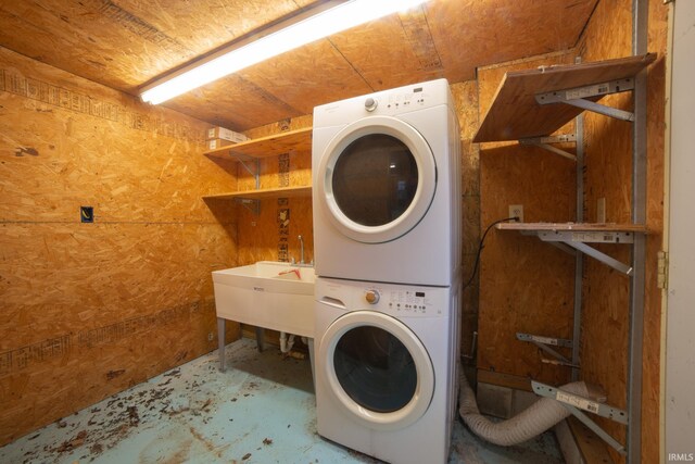 laundry area featuring laundry area, stacked washer / drying machine, and a sink