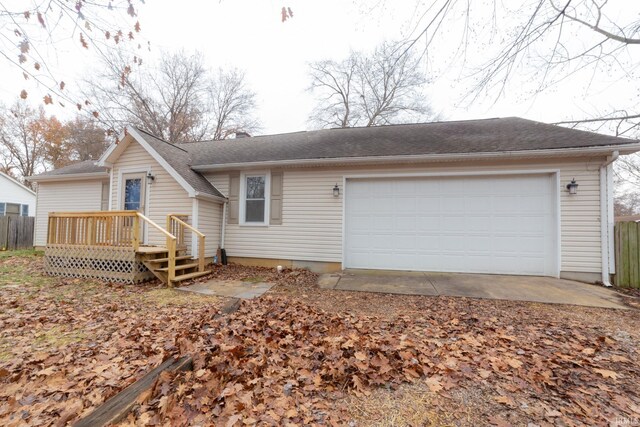 single story home with a garage, a wooden deck, and fence