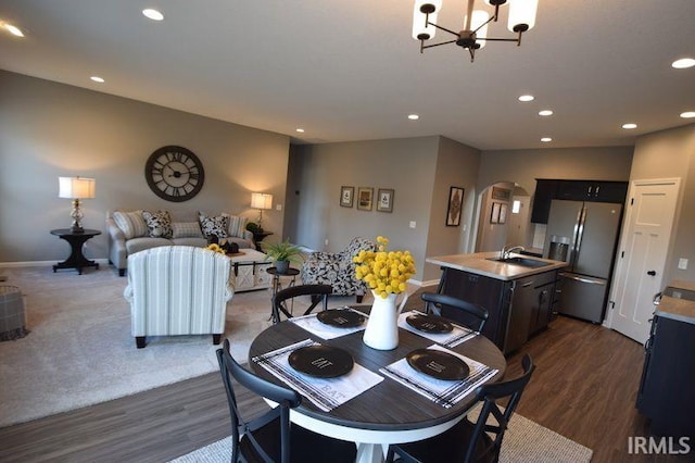 dining room with an inviting chandelier, dark wood-type flooring, and sink