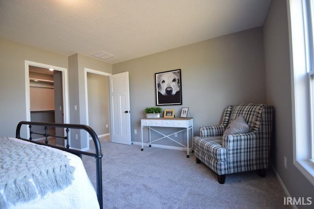 bedroom featuring light carpet and a textured ceiling