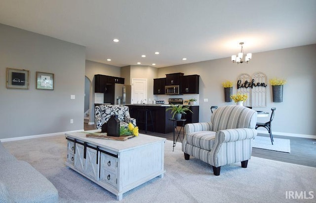 living room featuring light colored carpet and an inviting chandelier