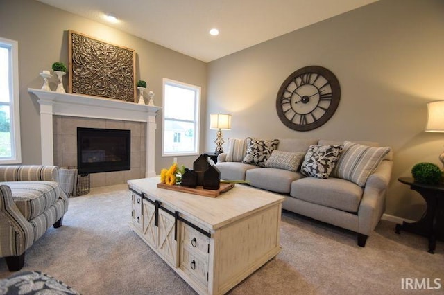 carpeted living room featuring a tile fireplace