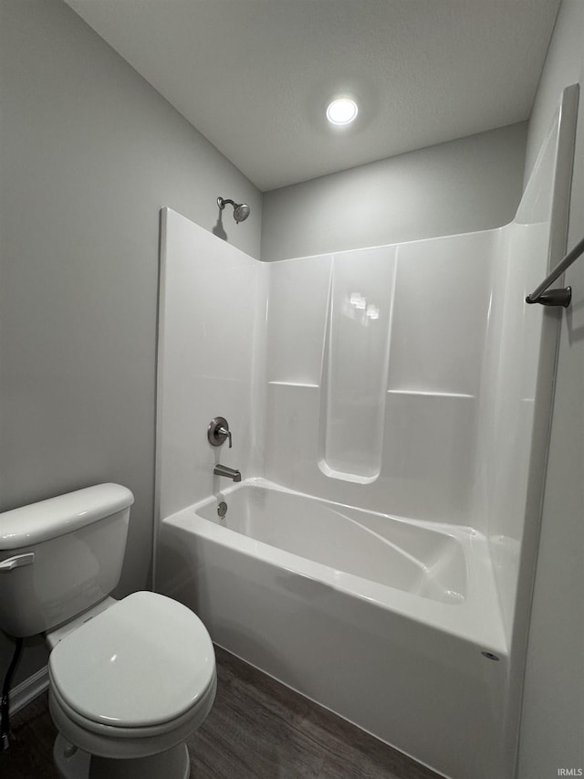 bathroom featuring wood-type flooring, shower / tub combination, and toilet