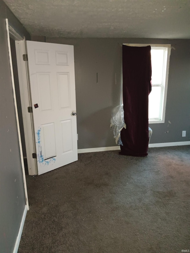 carpeted empty room featuring a textured ceiling