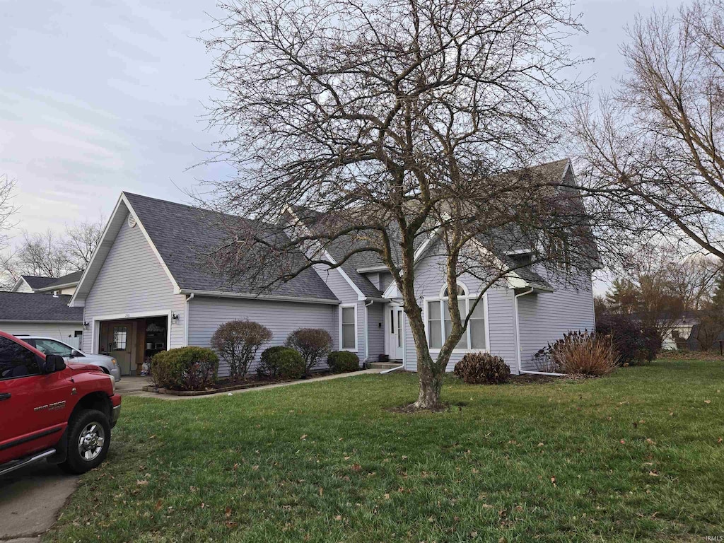 front of property with a garage and a front lawn