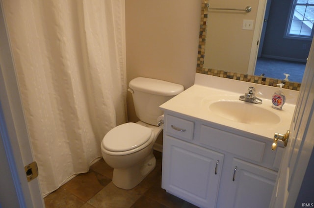 bathroom with toilet, vanity, and tile patterned floors