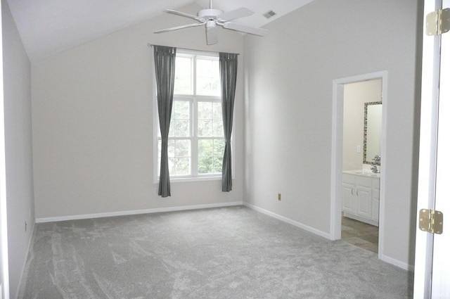 unfurnished bedroom featuring ensuite bathroom, ceiling fan, sink, carpet floors, and lofted ceiling