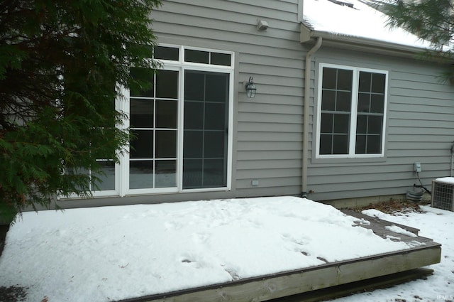 snow covered property entrance featuring cooling unit