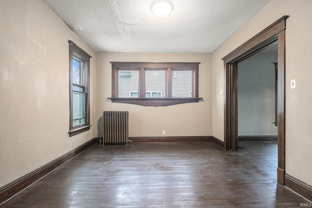 unfurnished room featuring a textured ceiling, dark wood-type flooring, and radiator