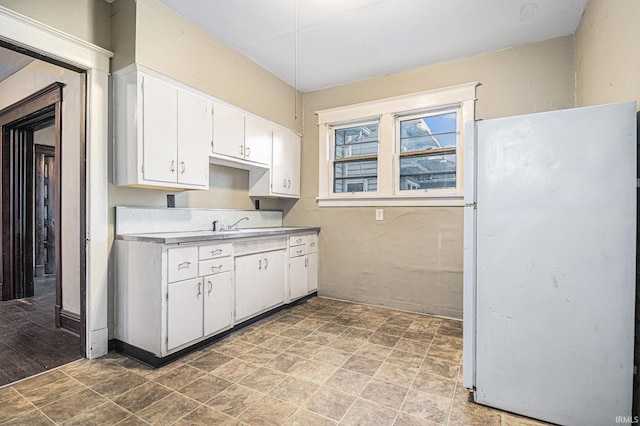 kitchen featuring white cabinets and white refrigerator