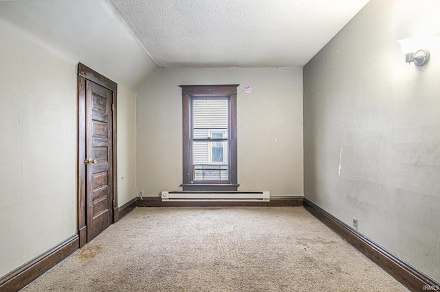 carpeted spare room with a textured ceiling, baseboard heating, and lofted ceiling