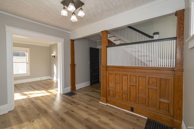 unfurnished dining area with a textured ceiling, wood-type flooring, and crown molding