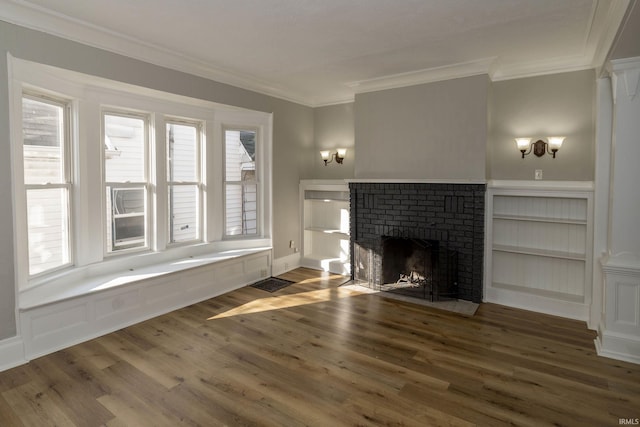 unfurnished living room with plenty of natural light, ornamental molding, dark wood-type flooring, and a brick fireplace