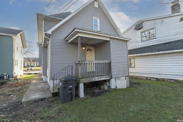 view of front of property featuring a front yard and a wall mounted air conditioner