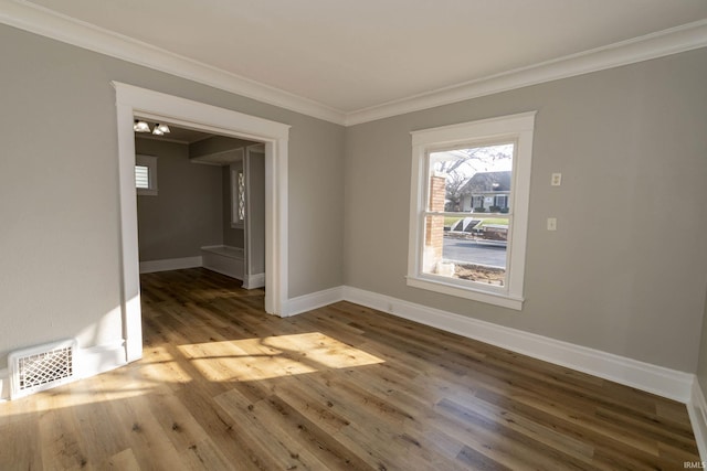 empty room with hardwood / wood-style floors and ornamental molding