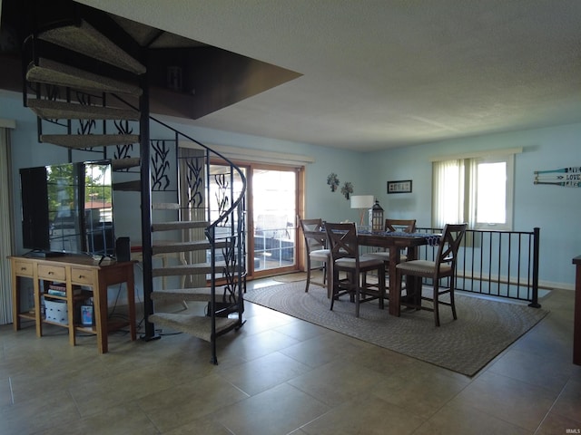 tiled dining area featuring a textured ceiling