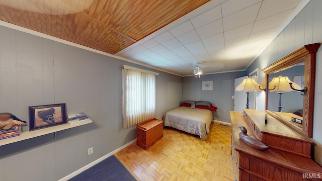 bedroom featuring wooden walls, light parquet flooring, and ornamental molding