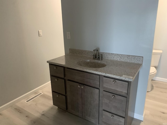 bathroom featuring hardwood / wood-style floors, vanity, and toilet