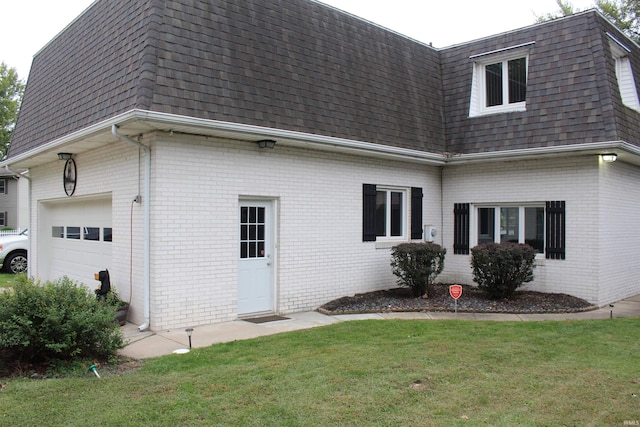 back of property featuring a lawn and a garage