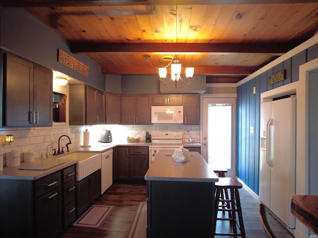 kitchen featuring sink, dark hardwood / wood-style flooring, a chandelier, white appliances, and a kitchen island