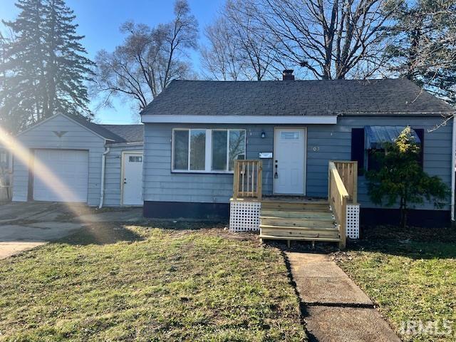 view of front of property with a garage and a front lawn