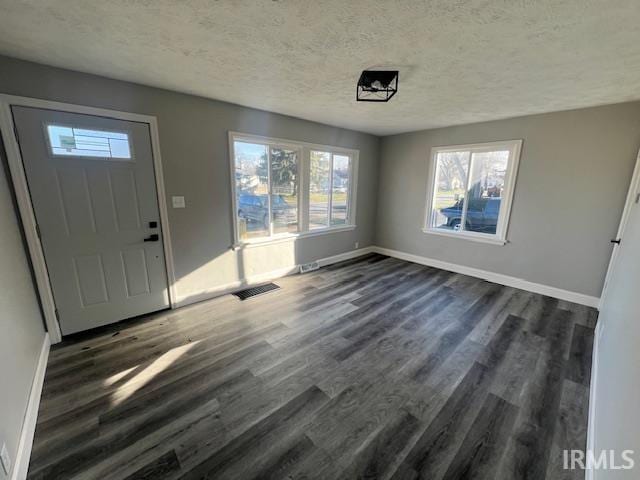 foyer entrance featuring dark hardwood / wood-style flooring and a textured ceiling