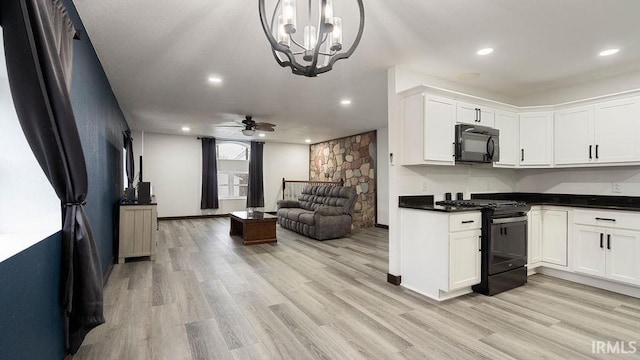 kitchen featuring white cabinetry, light hardwood / wood-style flooring, black appliances, and ceiling fan with notable chandelier