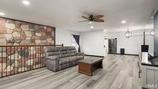 living room featuring light hardwood / wood-style flooring and ceiling fan with notable chandelier