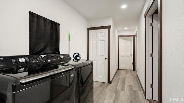 washroom featuring washing machine and dryer and light wood-type flooring