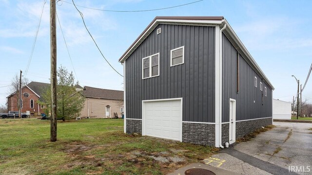 view of side of property with a yard and a garage