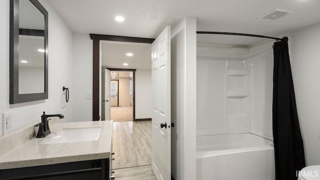 bathroom featuring shower / bathtub combination with curtain, hardwood / wood-style floors, and vanity