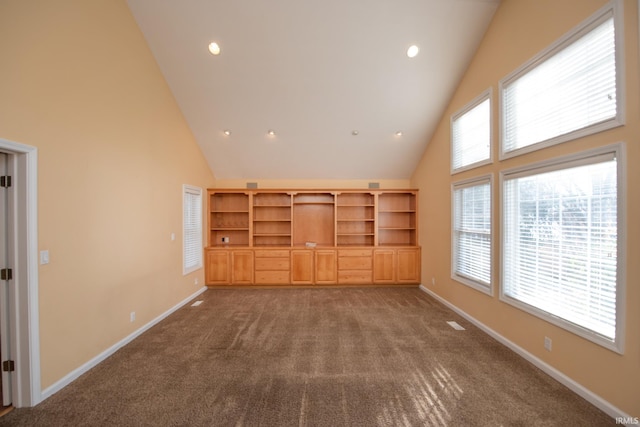 unfurnished living room with carpet flooring and high vaulted ceiling