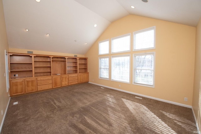 unfurnished living room with dark colored carpet and vaulted ceiling