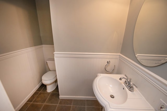 bathroom featuring toilet, tile patterned floors, and sink