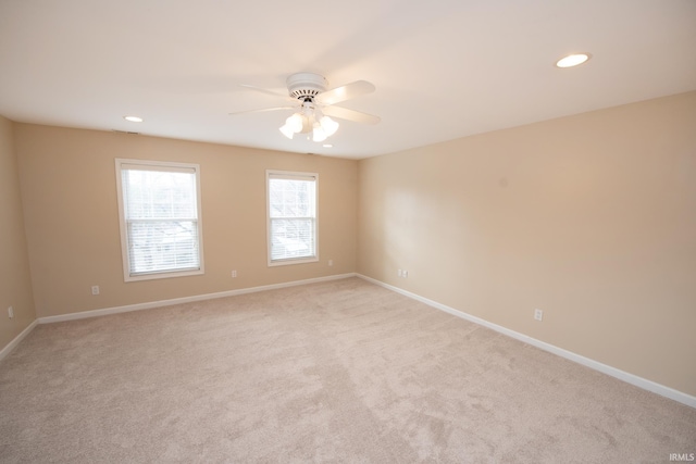 carpeted spare room with ceiling fan