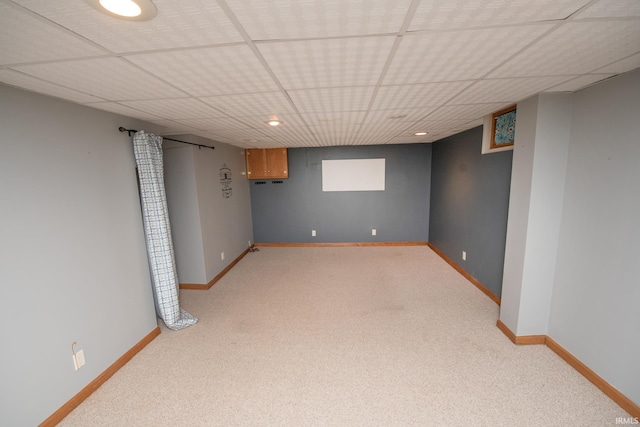 basement featuring light carpet and a drop ceiling