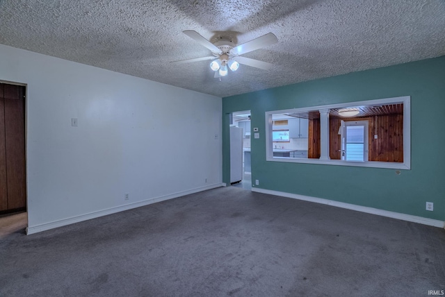 carpeted empty room featuring ceiling fan and a textured ceiling