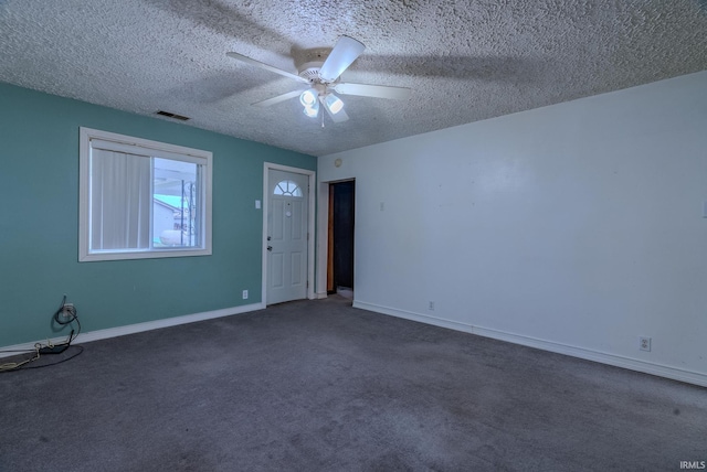 carpeted empty room with ceiling fan and a textured ceiling