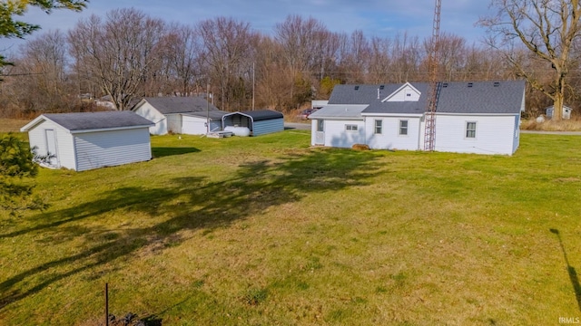 view of yard featuring a carport and an outbuilding