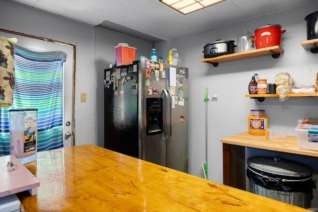 kitchen featuring stainless steel fridge and butcher block counters