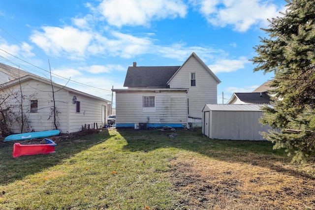 rear view of property with a lawn, a storage shed, and central air condition unit