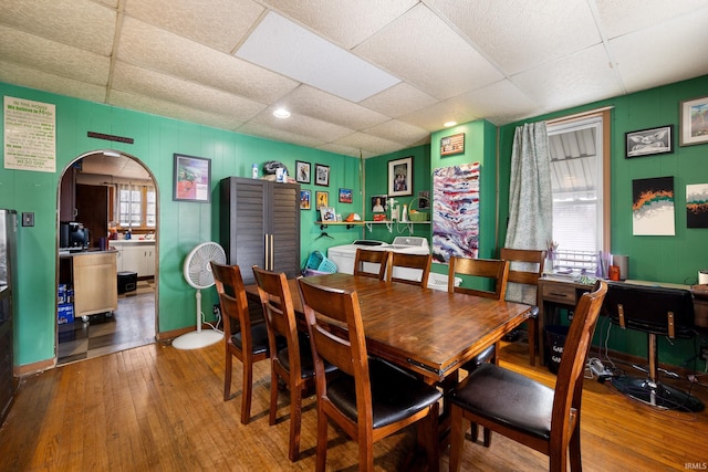 dining room featuring a paneled ceiling and hardwood / wood-style flooring