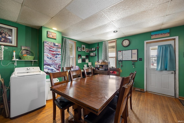 dining room with washer / clothes dryer, a paneled ceiling, and hardwood / wood-style flooring