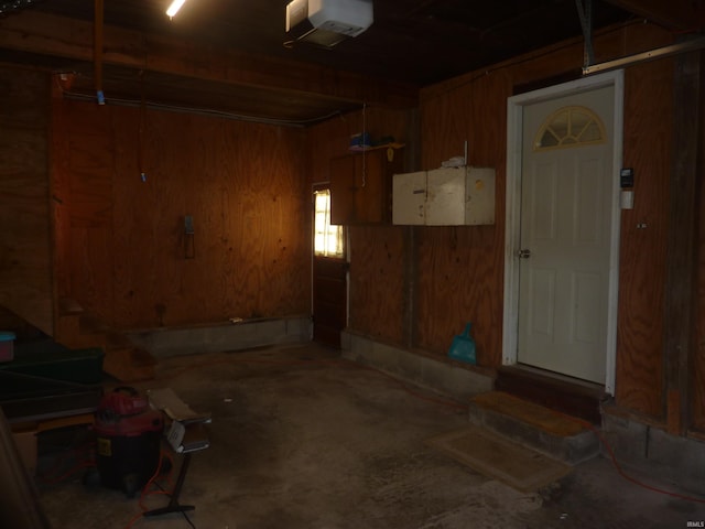 garage with wood walls and a garage door opener