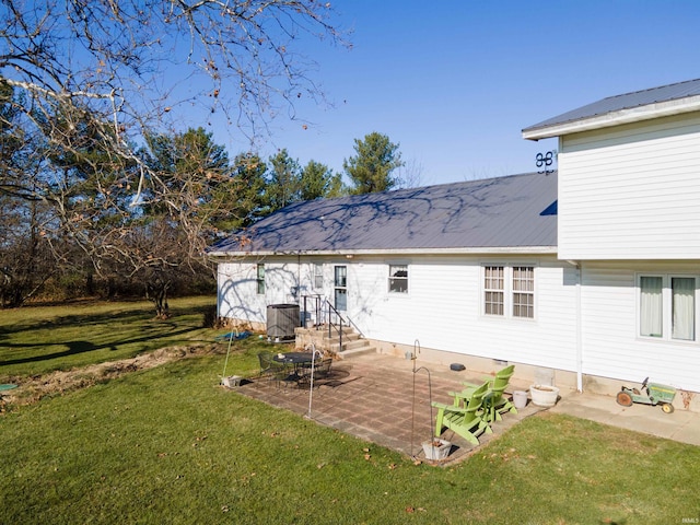 back of house with central AC unit, a patio area, and a lawn